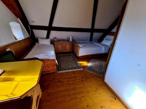 an attic room with two beds and a desk at Armenopolis - Adults Only in Gherla