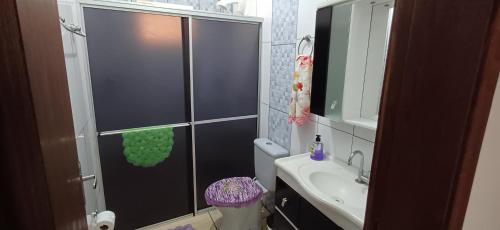 uma casa de banho com um chuveiro, um WC e um lavatório. em Ap térreo a 50 metros do mar em Balneário Gaivotas