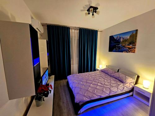 a bedroom with a bed and a flat screen tv at Garsoniera Residence Militari in Chiajna