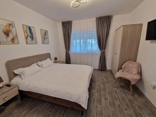 - une chambre avec un lit, une chaise et une fenêtre dans l'établissement Home in Residential Neighborhood, à Arad