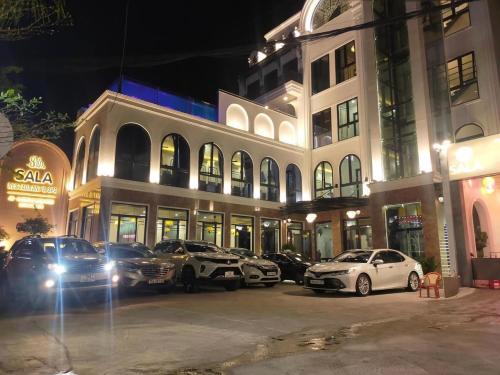 a group of cars parked in a parking lot in front of a building at SALA HOTEL HUE in Hue