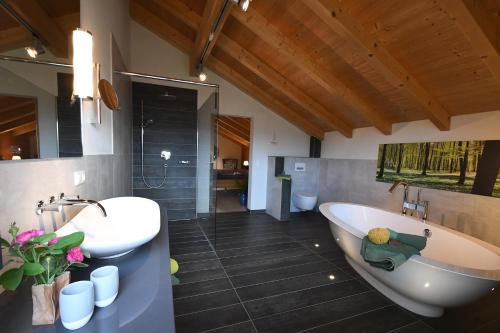 ツヴィーゼルにあるChalet Zauberbergのバスルーム(バスタブ、洗面台、トイレ付)