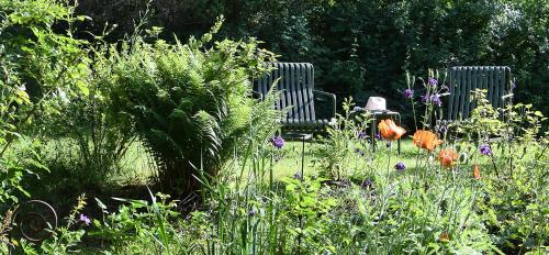 two chairs in a garden with flowers and plants at Chalet Zauberberg in Zwiesel