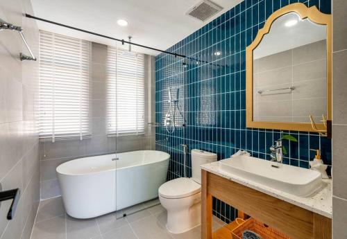 a bathroom with a tub and a toilet and a sink at Coastal Sunshine Villa NovaWorld Phan Thiết in Bình Tú
