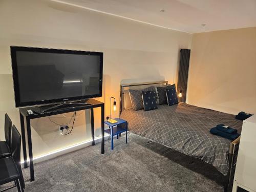 a bedroom with a large flat screen tv and a bed at Carlisle City Centre The Wash House in Carlisle