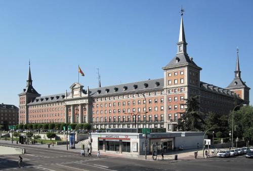 - un grand bâtiment en briques avec une rue en face dans l'établissement Chic Central Madrid, à Madrid