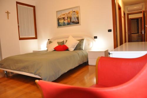 a bedroom with a bed and a red chair at Ex Casa degli Artisti in Montebelluna