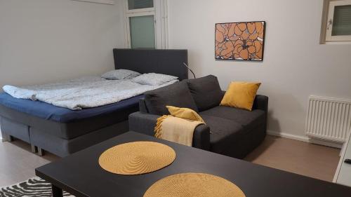 a living room with a couch and a table at Moderni ja supermukava asunto! 65'Smart TV, Valokuitunetti, lähellä yliopistoa! in Lappeenranta
