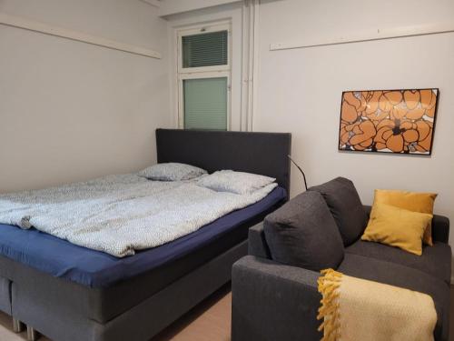 a bed and a couch in a room at Moderni ja supermukava asunto! 65'Smart TV, Valokuitunetti, lähellä yliopistoa! in Lappeenranta