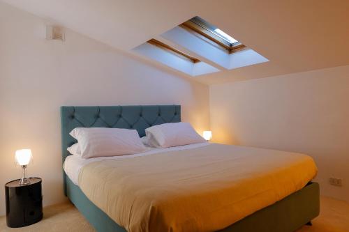 a bedroom with a large bed with a blue headboard at greve center apartments in Greve in Chianti