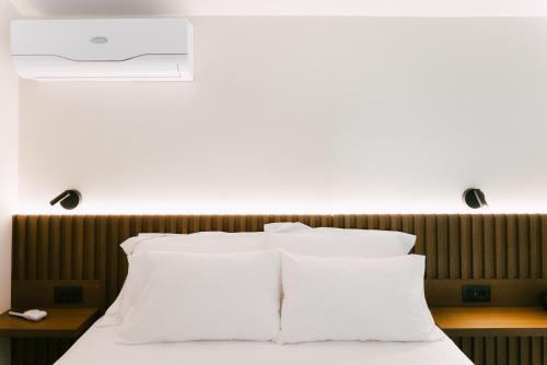 a bed with white pillows in a room at LAN-GO SIVOTA Luxury Living in Sivota