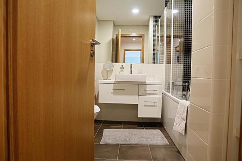 a bathroom with a sink and a mirror at Apartamento Lux 1882 in Figueira da Foz