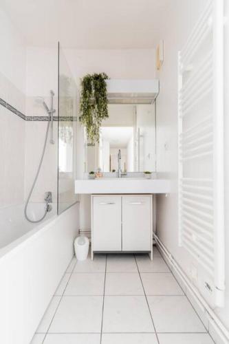 une salle de bain blanche avec un lavabo et une douche dans l'établissement Emplacement idéal proche Disney, à Serris