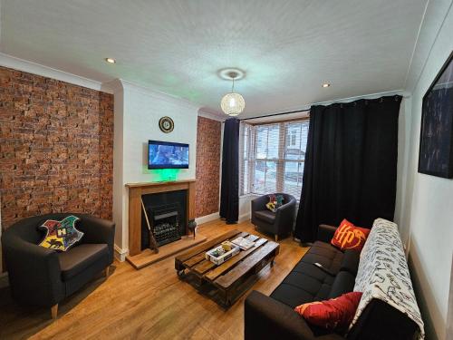 sala de estar con sofá y chimenea en MAGICAL HARRY POTTER HOME IN WATFORD with FREE off-street PARKING en Watford