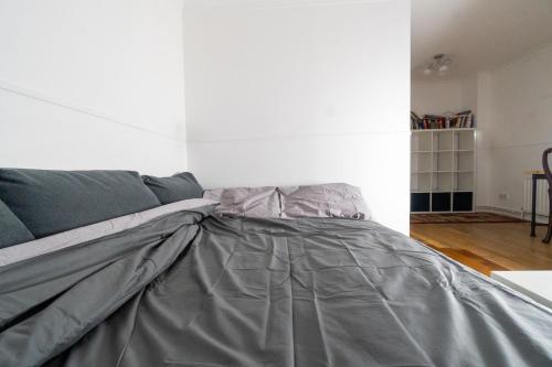 - un lit avec une couette grise dans l'établissement Lake view private room, desk, 1 Gbps net, free parking, à Londres