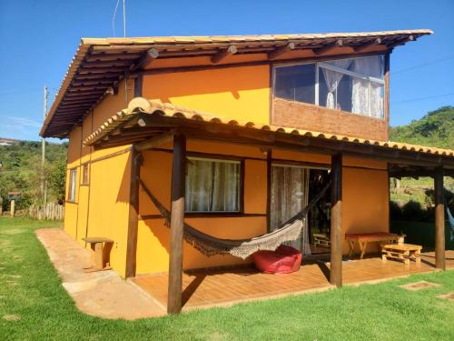 a house with a hammock in front of it at Casa do Rogério in Santana do Riacho