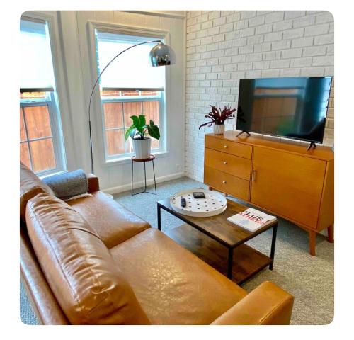 a living room with a leather couch and a flat screen tv at Toadhaus Studio in quiet residential neighborhood ATHENS in Athens