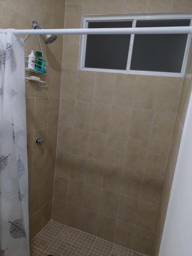 y baño con ducha y ventana. en Casa de descanso en residencial, en Tlayecac
