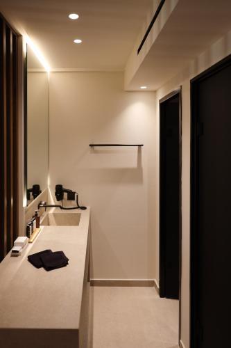 a white bathroom with a sink and a mirror at LAN-GO SIVOTA Luxury Living in Sivota