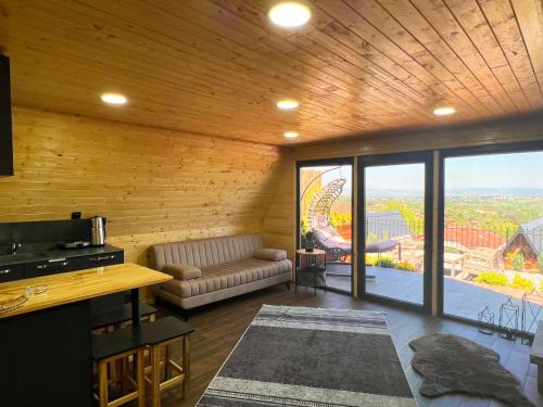ein Wohnzimmer mit einem Sofa und einem großen Fenster in der Unterkunft Kartepe Vista Bungalov in Kartepe