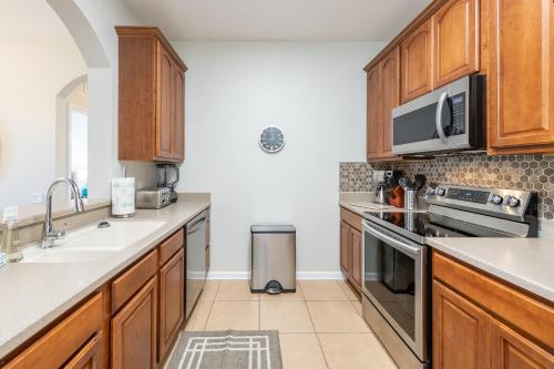 a kitchen with wooden cabinets and a sink at VistaCay Balcony near Pool Convention Ctr iDrive in Orlando