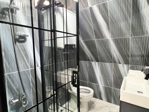 a bathroom with a toilet and a glass shower at Kartepe Vista Bungalov in Kartepe