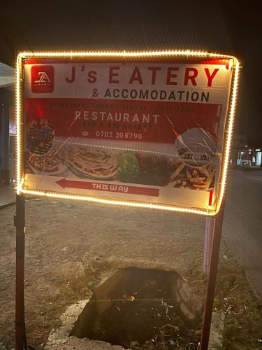 una señal que está al lado de una carretera en J's Hotel & Accomodation, en Nakuru