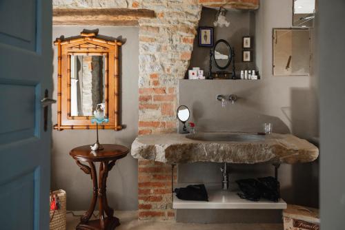 a bathroom with a stone sink and a mirror at Tenuta Bricchi in Sinio