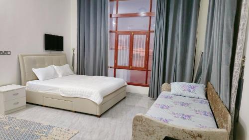 Al Ashkhara Beach House في الشرقية: غرفة نوم بسرير وكرسي ونافذة