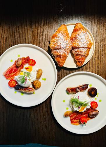two plates of food on a wooden table with bread at Zoe Bistro & Accommodation in Kilrush