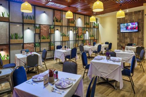 comedor con mesas y sillas y TV en Rado Hotel - Quintanas, en Trujillo