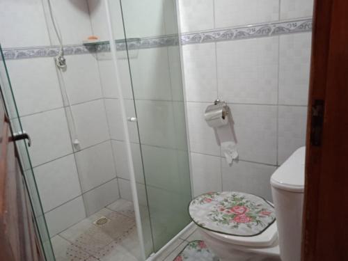 een badkamer met een toilet en een glazen douche bij Pertinho da Mata Kitnete in Cachoeiras de Macacu