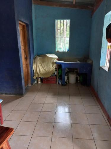 a blue room with a table and a tiled floor at Cabinas Chavez in Rivas