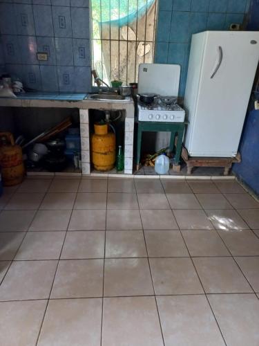 a kitchen with a counter and a stove and a floor at Cabinas Chavez in Rivas
