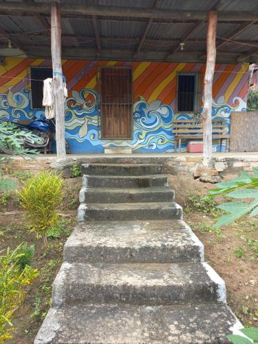 a building with stairs in front of a mural at Cabinas Chavez in Rivas