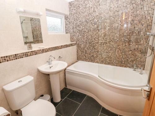 a bathroom with a sink and a toilet and a bath tub at Egret in Milford Haven