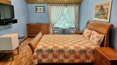 a bedroom with a bed and a dresser and a window at Pousada Recanto Lisieux in Marechal Floriano