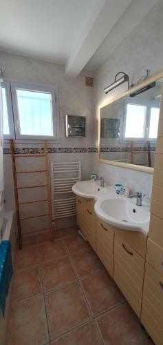 une salle de bain avec deux lavabos et un miroir dans l'établissement Maison bleu océan, à Saint-Palais-sur-Mer