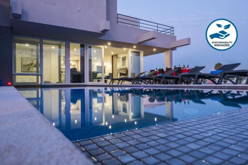 a house with a swimming pool with tables and chairs at Villa Bonita Brenda by Algarve Vacation in Armação de Pêra