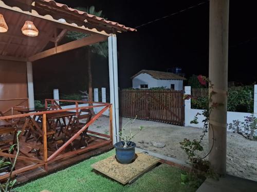 eine Terrasse in der Nacht mit einem Zaun und einem Haus in der Unterkunft Essência de Atins in Atins
