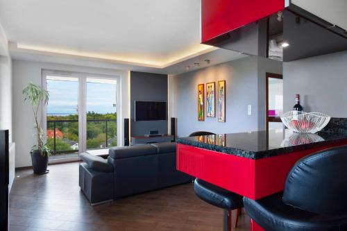 a kitchen and living room with a couch and a table at Elite Apartments Seaview Tower in Gdańsk
