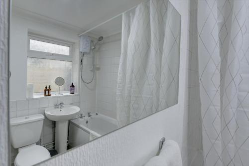 a white bathroom with a sink and a toilet and a tub at Modern 2BR Gem I Free Parking I Sleeps 5 in Coventry