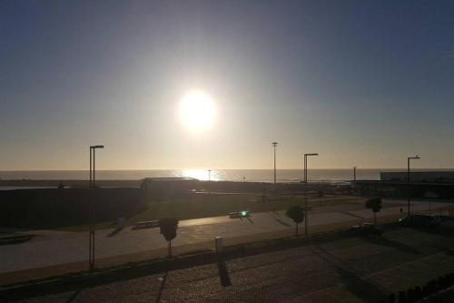 ein Sonnenuntergang über einem Parkplatz mit dem Meer in der Unterkunft Appartement de 90 m2 en 1ere ligne face a l'ocean in Vila Praia de Âncora