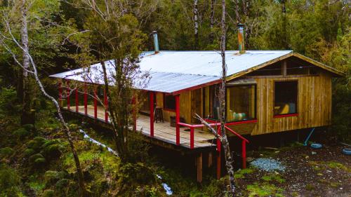 a cabin in the woods with a metal roof at Cabañas Tierra Hermosa in Hornopiren