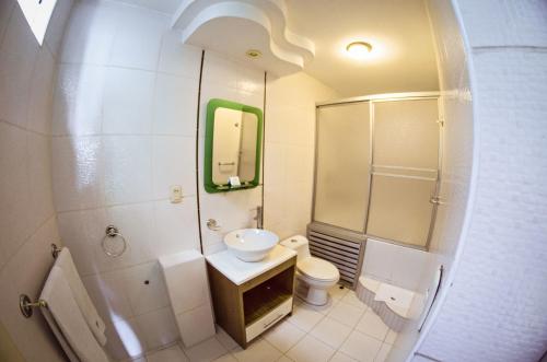 a bathroom with a sink and a toilet and a mirror at Gran Bolivar Hotel - Trujillo, Perú in Trujillo