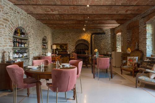 a dining room with a table and pink chairs at Tenuta Bricchi in Sinio