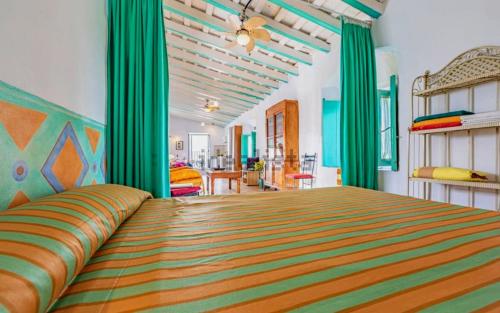 a bedroom with a large bed with green curtains at La Plaza de Conil in Conil de la Frontera