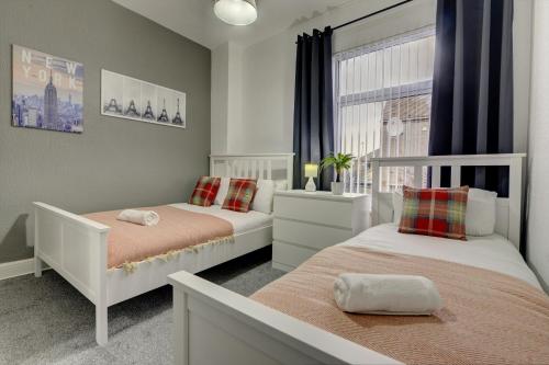 een slaapkamer met 2 bedden en een raam bij Modern 2BR Gem I Free Parking I Sleeps 5 in Coventry