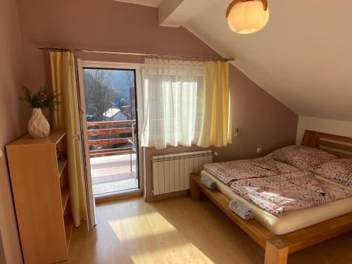 a bedroom with a bed and a large window at Nad Strumykiem APARTAMENT in Ochotnica Dolna