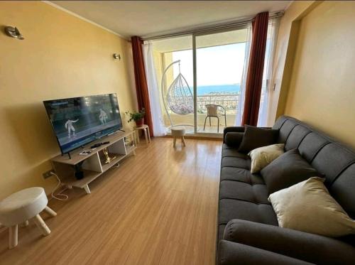a living room with a couch and a flat screen tv at Departamento con vista al mar in Viña del Mar
